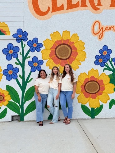 Clermont in Bloom t-shirts worn in front of the Downtown Clermont mural